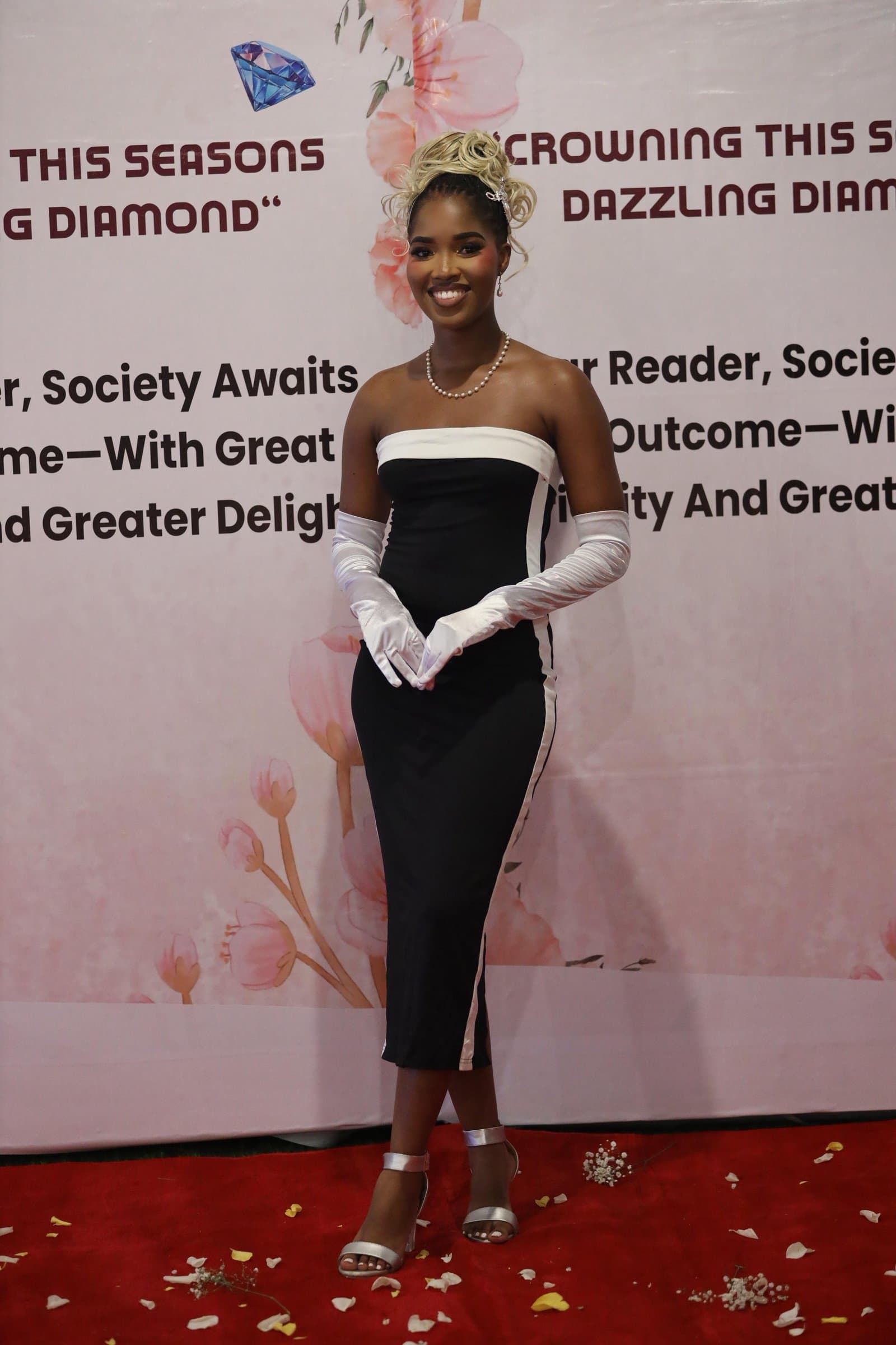 Primrose on the red carpet in a black and white strapless dress and opera gloves